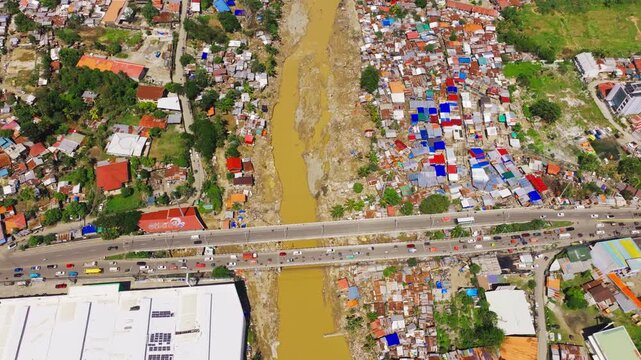 Aerial view of dense riverside housing and bridge in Talisay Cebu after floods