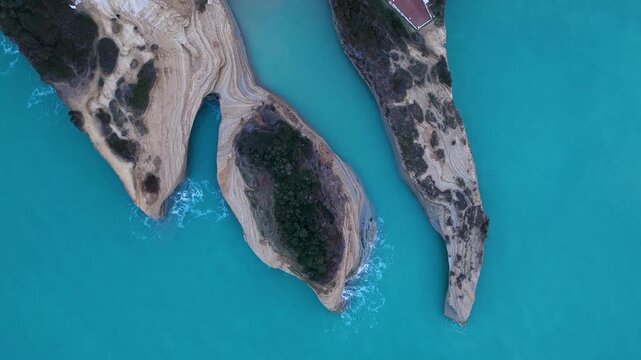 Top down aerial drone view of unique geological rock formations at Canal d'Amour, Sidari, Corfu, Greece, with textured sandstone cliffs and blue Ionian Sea water