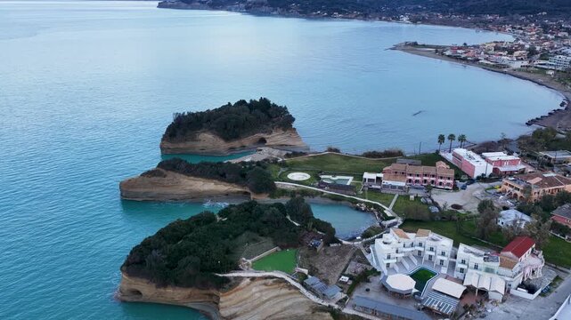 Aerial view of the famous Canal d'Amour rock formations and coastline in Sidari, Corfu Island, Greece, featuring unique sandstone cliffs, turquoise Ionian Sea waters, coastal resorts