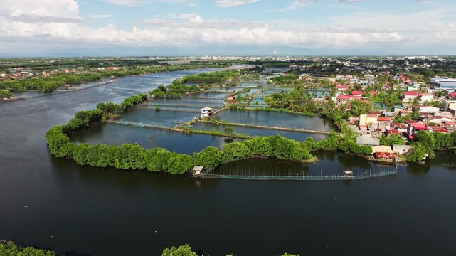 Slow drone flight green fishpond grids and calm waters in Pangasinan Philippines