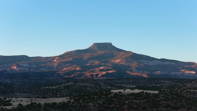 Wide drone view of Abiquiu Lake and a flat-top mountain in the New Mexico desert. A cinematic background plate for travel, nature, or science fiction.