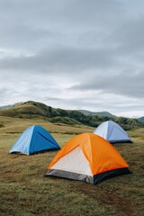 Colorful tents in scenic mountain landscape under cloudy sky
