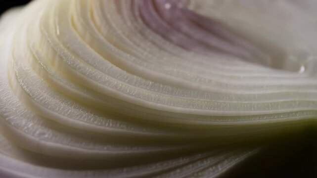 A close-up of chopped onions in a product with a creamy texture and swirls.