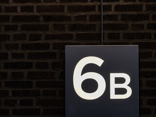Sign showing number 6B on a building in Gothenburg Sweden against a dark brick wall