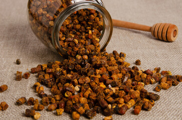 Fresh bee bread on spoon on wooden table, close-up