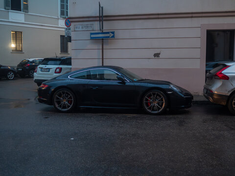 Porsche 911 Carrera 991 parked on an urban street, showcasing luxury sports car design and German engineering performance