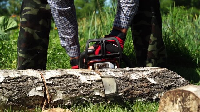 gardener with chainsaw in the garden