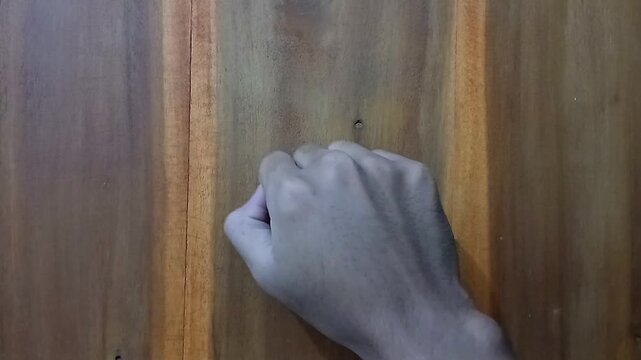 knocked on the brown wooden patterned door. knocking repeatedly