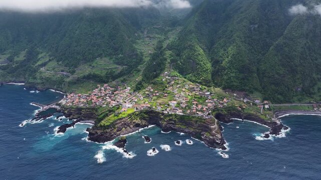 Scenic setting of Seixal on Madeira between ocean and lush mountains, aerial