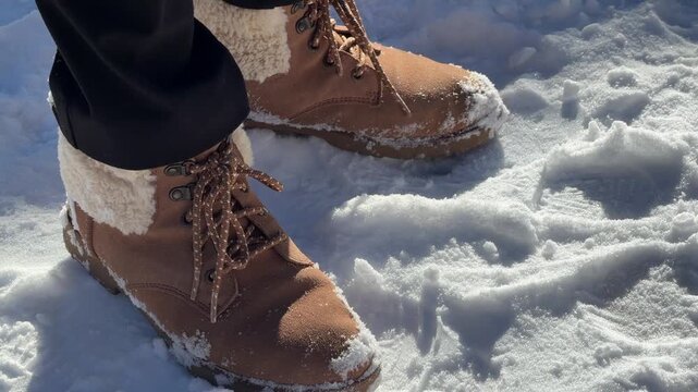 Person walking in snow wearing winter Ugg boots.