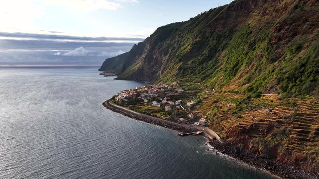 Terraces on coastal slopes of Jardim do Mar at sunset on Madeira shore. Aerial