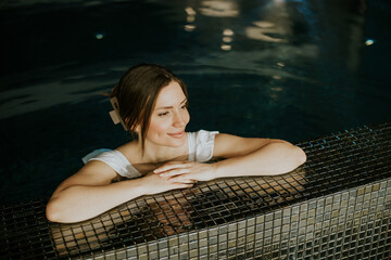 Woman enjoys time in a pool while relaxing in a spa setting