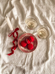 Candle with red ribbon and macaroons on a vintage plate