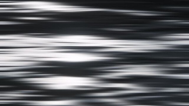 Reflets et ondulations du soleil sur l'eau au ralenti, avec effet flou gaussien horizontal