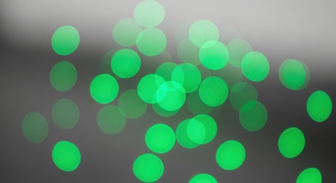 A vibrant and dynamic abstract image featuring numerous bright green dots scattered across a dark gray background with a subtle gradient effect