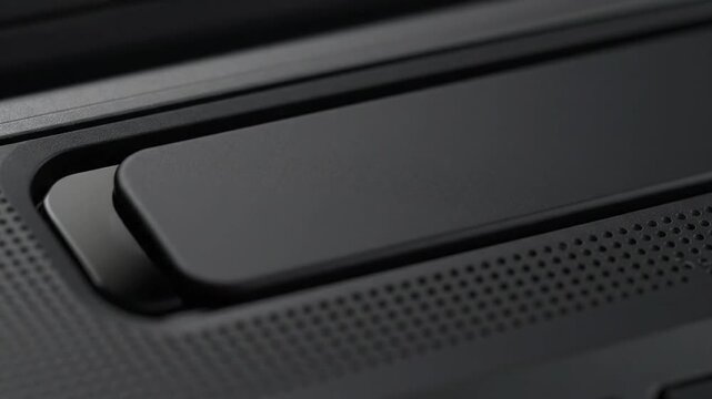 The close-up footage captures a dark physical privacy shutter smoothly sliding shut, fully obscuring the webcam lenses on an electronic device, highlighting security features.