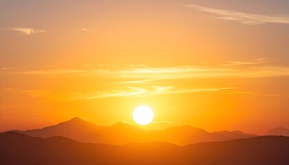 Obraz premium Sunset with a bright sun over dark silhouetted mountains, vibrant colors of orange and yellow fill the sky