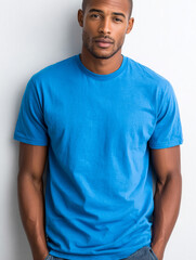 Fototapeta premium Confident man in blue t-shirt standing against white wall