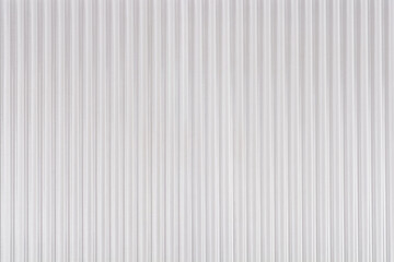 Obraz premium A full frame view of a white translucent corrugated plastic sheet with vertical ridges
