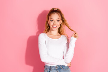 Happy young blond woman posing with cheerful expression wearing casual white shirt against pink...