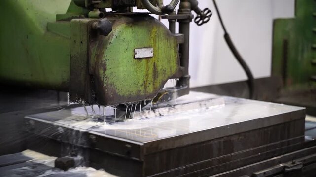 Close-up of a grinding machine smoothing a steel mold part in a factory. Concept of precision engineering, industrial manufacturing business, and production finance.