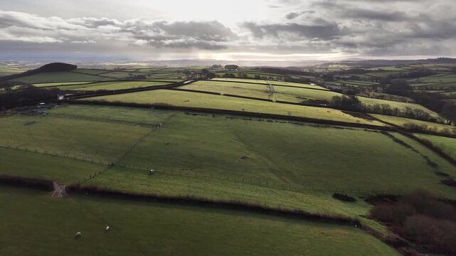 West Country farmland with dawn light rising over Bodmin Moor on the horizon
