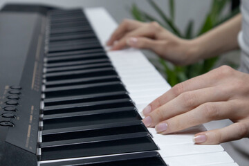 Obraz premium Woman playing digital piano at home for leisure.