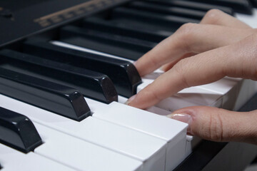 Fototapeta premium Woman playing digital piano at home for leisure.