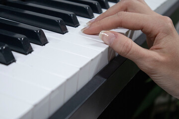 Fototapeta premium Woman playing digital piano at home for leisure.