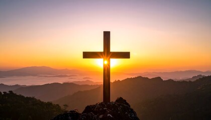 Wooden cross stands on a mountain top as the sun rises/sets behind it, emitting light and setting the sky ablaze