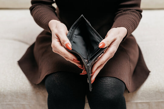 Woman showing empty wallet in hands. Business, finance and money shortage concept.