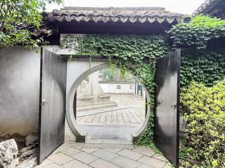 Enchanting Circular Gate Framed by Lush Greenery in a Serene Garden Retreat