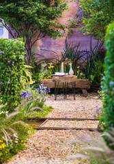 Tranquil Outdoor Dining Area Surrounded by Lush Greenery and Blossoming Flowers
