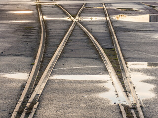 Old railway tracks in Gothenburg show signs of wear and reflect the surrounding environment