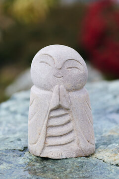 Smiling Stone Monk Statue Praying Hands Namaste Zen Garden Sculpture Close-Up