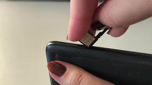 The hand inserts the SIM tray into the phone. Mobile communication. Communication. Internet