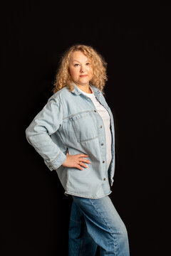 Mature woman in casual denim shirt posing with hand on hip. Successful business owner. Business portrait of designer, businesswoman, successful woman 56 years old