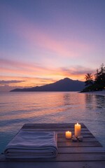 Fototapeta premium Candles, towels on wooden dock at sunset, calm lake, mountain silhouette in twilight hues.