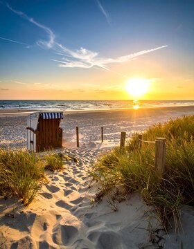 A tranquil beach scene at sunset. Sandy path leads to wooden shelter by the shore, tall grass flanks the way, and a vibrant sky