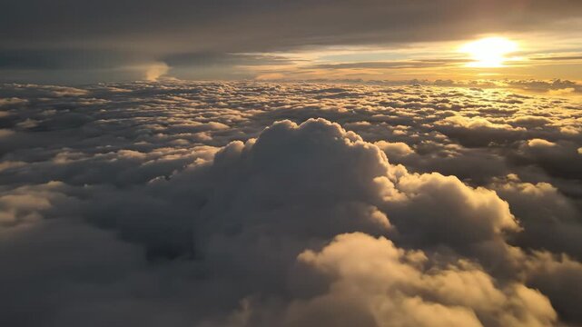 Beautiful golden sunrise above fluffy clouds creating a serene and expansive sky view