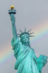 Fototapeta premium Statue of Liberty closeup with rainbow sky in the background. Vertical. New York City.