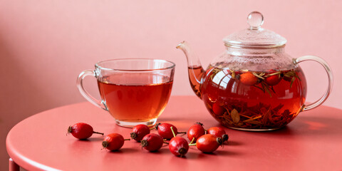 Glass teacup and teapot filled with rosehip herbal tea