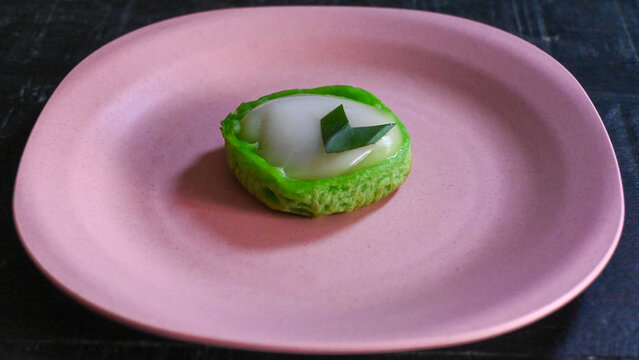 Close Up of Traditional Indonesian Kue Talam Pandan Dessert on Pink Plate