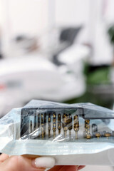 Set of dental burs and attachments in sterile packaging for professional tooth treatment in a dental clinic.