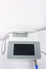 Dental device with touchscreen display and turbine handpiece on white background in clean minimalist clinic style.