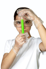 Young scientist holding a bright green test tube in a lab, wearing protective gloves and goggles