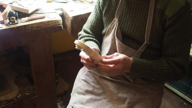 Skilled violinmaker meticulously carving a new violin scroll in a traditional workshop