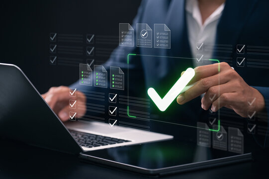 digital document approval and task management. businessman using digital checklist interface on laptop screen with green check mark symbol for document approval and task completion.