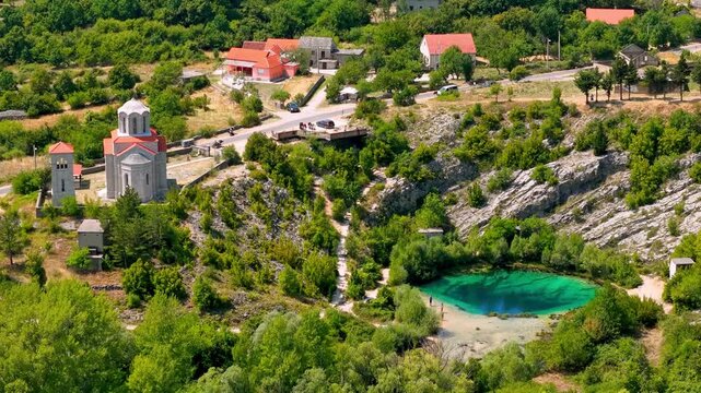 Aerial view of Cetina River source near Vrlika Croatia with turquoise karst spring village and historic church