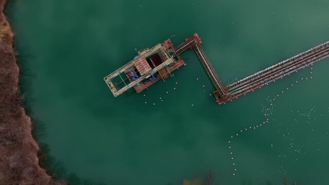Excavator Loading Sand and Gravel at Water Filled Quarry